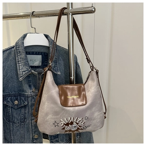 Detail of grey marble-textured tote bag with brown leather flap and stylish printed logo