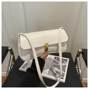 Gros plan du sac à bandoulière blanc à motif crocodile avec son fermoir en métal doré chic