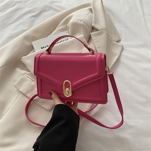 Fuchsia rectangle crossbody bag with gold lock and V-embossed flap on blazer