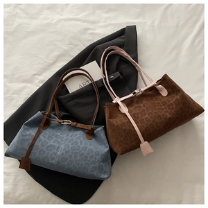 Vue à plat de sacs fourre-tout léopard vintage en bleu et caramel sur tissu blanc