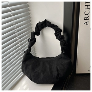 Vue détaillée du sac demi-lune en daim noir avec poignée plissée et texture mate