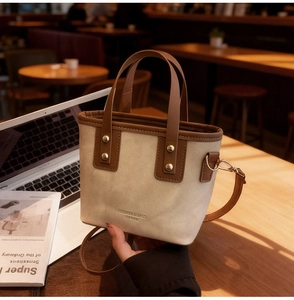 Detailed shot of mini canvas tote bag with brown leather trim on a cafe table