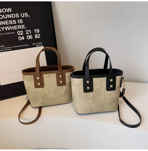 Detail of vintage tote bag with rivets and Fashion Leather text on smooth suede