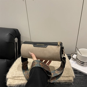 Khaki suede cylinder crossbody bag with wide floral strap and gold fashion lettering