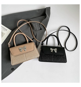 Detail von Pailletten-Taschen in Beige und Schwarz mit Metall-Schleifen und Riemen
