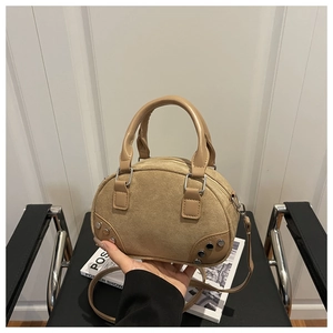 Dettaglio borsa bowling kaki in pelle scamosciata con borchie e manici in pelle