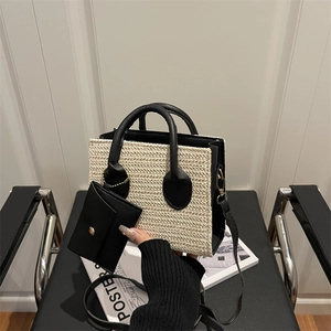 Sac à main en paille et cuir avec mini pochette amovible sur une chaise noire