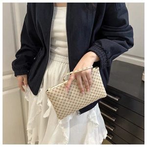 Close-up of beige printed envelope clutch bag with geometric pattern and wristlet strap