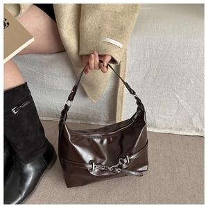 Detail of dark brown leather shoulder bag with silver buckle and smooth polished finish
