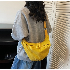 Bright yellow nylon crescent bag shown worn cross-body to demonstrate large capacity size