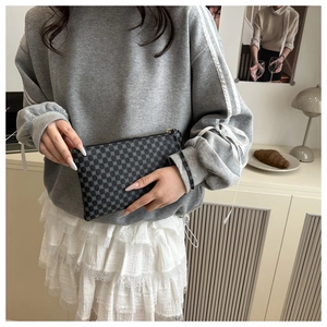 Detailed view of rectangular clutch bag with retro geometric pattern and zipper