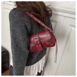 Detail view of burgundy punk shoulder bag with silver studs and decorative buckle