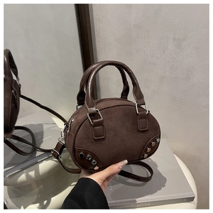 Vista dettagliata della borsa bowling vintage marrone scuro con borchie e finitura opaca