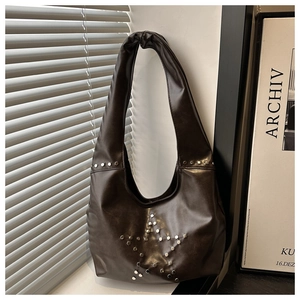 Macro detail of silver star studs on dark brown leather hobo bag with moon shape