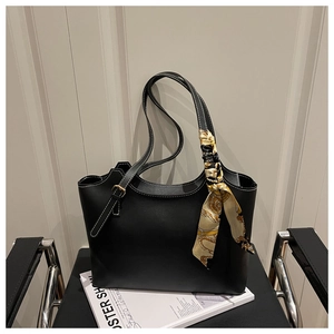 Detail of black tote bag featuring contrast white stitching and a decorative silk scarf