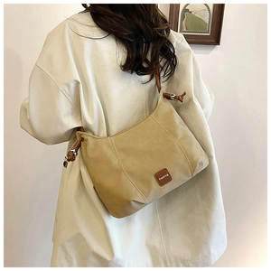 Rear view of khaki crossbody bag showing back fit and adjustable brown leather strap