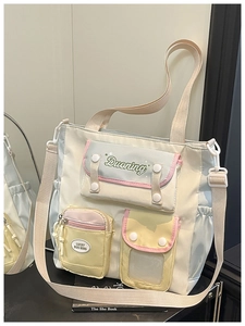 Detailed view of a multi-pocket nylon shoulder bag in soft pastel patchwork colors