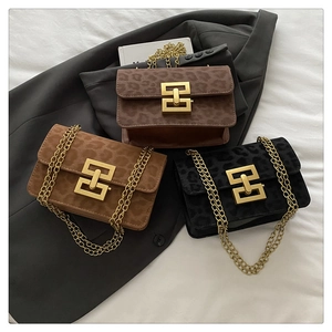 Three leopard print crossbody bags with gold chains and geometric metal locks on a blazer