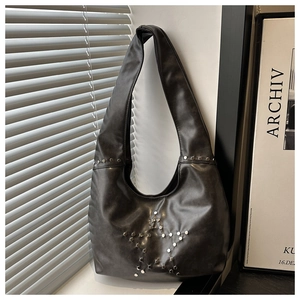Detail of silver star rivet pattern on black leather hobo shoulder bag with urban vibes
