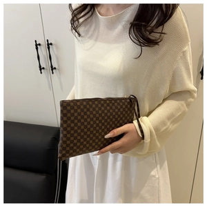 Detailed shot of brown vintage monogram envelope clutch with metal zipper and wrist strap