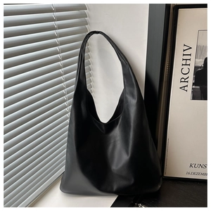 Detail of minimalist black matte leather tote bag with elegant window light and shadow