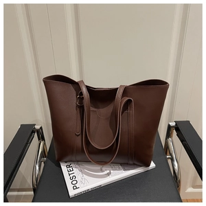 Detail view of large dark brown PU leather tote bag with front pocket and adjustable strap