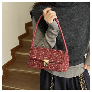 Détail du sac à bandoulière en tweed rouge avec fermoir doré et texture tissée