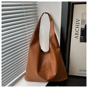 Minimalist caramel brown leather Hobo bag shown with natural light shadow details