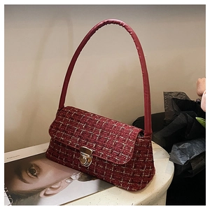 Dettaglio della borsa a spalla in tweed rosso con chiusura metallica dorata e trama tessuta