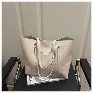 Detailed close-up of beige faux leather texture and front pocket on minimalist tote bag