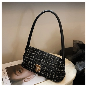 Dettaglio della borsa a tracolla in tweed nero e oro con chiusura a scatto metallica
