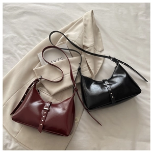 Close-up of vintage hobo bags in burgundy and black with silver studs and decorative straps