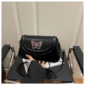 Detail der rosa Schmetterlingsstickerei auf schwarzer Ledertasche mit Metallschnalle