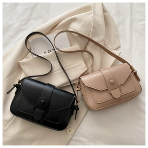 Detail of minimalist crossbody square bags in black and beige with round metal buckles