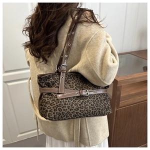 Detail view of leopard print tote bag with adjustable brown strap and silver buckles