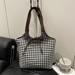 Classic black and white checkered tote bag with brown suede straps and a decorative bow