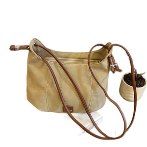 Minimalist khaki shoulder bag with dark brown strap and silver bead accents on white background