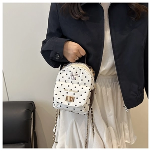 Mini sac à dos à pois avec fermoir rotatif doré et imprimé chat porté par un mannequin