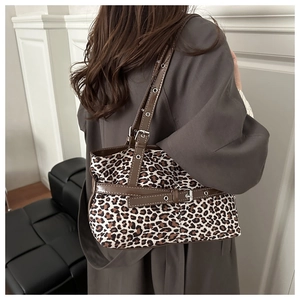 Detailed macro view of retro leopard print canvas texture and brown leather strap detail