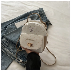 Détail du sac à dos blanc à pois avec imprimé chat et fermoir métallique doré pivotant