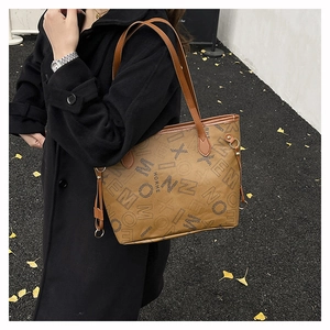 Photo de rue d'un sac cabas marron à imprimé vintage porté sur un manteau noir élégant
