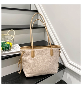 Detail of soft cream teddy fleece fabric with light brown leather trim on the tote bag