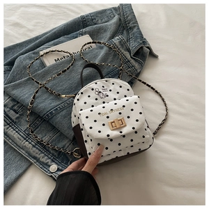 Détail du sac à dos blanc à pois avec imprimé chat, fermoir doré et bandoulière