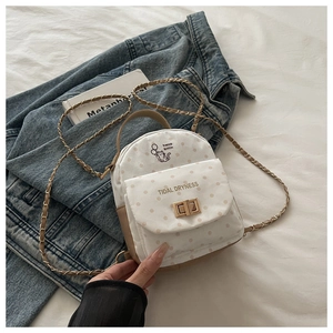 Détail d'un mini sac à dos à pois avec imprimé chat, fermoir doré et bandoulière