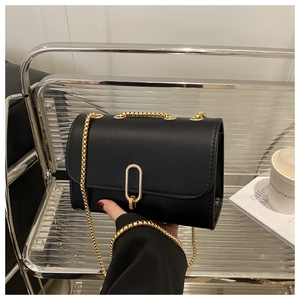 Gros plan du sac bandoulière noir avec fermoir doré et bandoulière chaîne pour femme