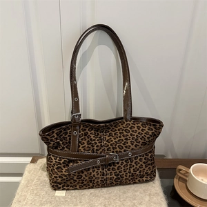 Retro leopard print tote bag with brown leather handles on a minimalist knit background