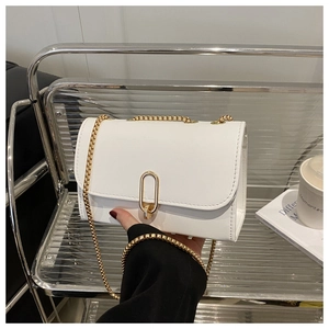 Détail du sac à rabat blanc avec bandoulière chaîne dorée élégante et boucle ovale en métal