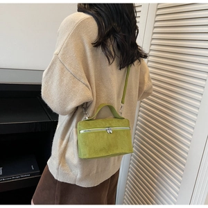 Détail du sac bandoulière en daim vert avocat avec double fermeture éclair et poignée supérieure