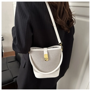 Detail showing the mixed texture of light grey woven fabric and white leather with gold lock