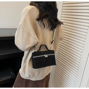 Détail du sac carré en daim noir mat avec fermeture éclair coeur argentée et bandoulière